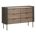 Moderná industriálna komoda Lavient s prírodne hnedými drevenými zásuvkami s kovovými úchytkami čiernym rámovaním a vysokými kovovými nožičkami