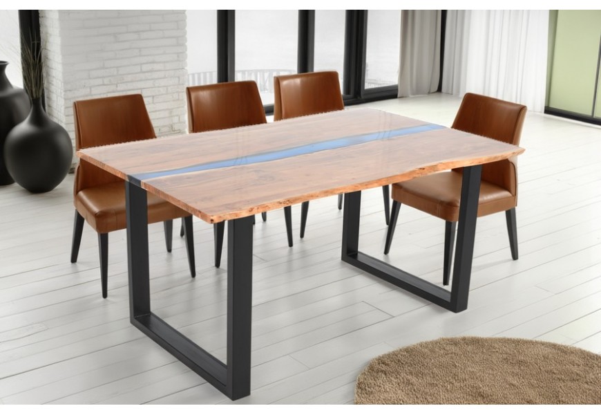 Masívny industriálny jedálenský stôl Aquila s obdĺžnikovou vrchnou doskou z akáciového dreva v naturálnej medovo hnedej farbe s modrým akcentovým detailom z umelej živice v strede s dvomi nohami z kovu v čiernej farbe v tvare U