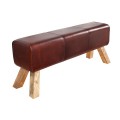 Industriálna kožená lavica Bock s čalúneným sedadlom v červenohnedej farbe a šikmými drevenými nožičkami s výraznou kresbou