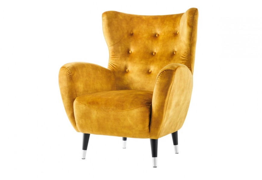 Dizajnové retro glamour zamatové žlté kreslo ušiak Bolte s vysokou chrbtovou opierkou s predĺženými rohmi s prešívaním s okrúhlymi gombíkmi so zaoblenými bočnými opierkami a šikmými čiernymi nožičkami so strieborným detailom