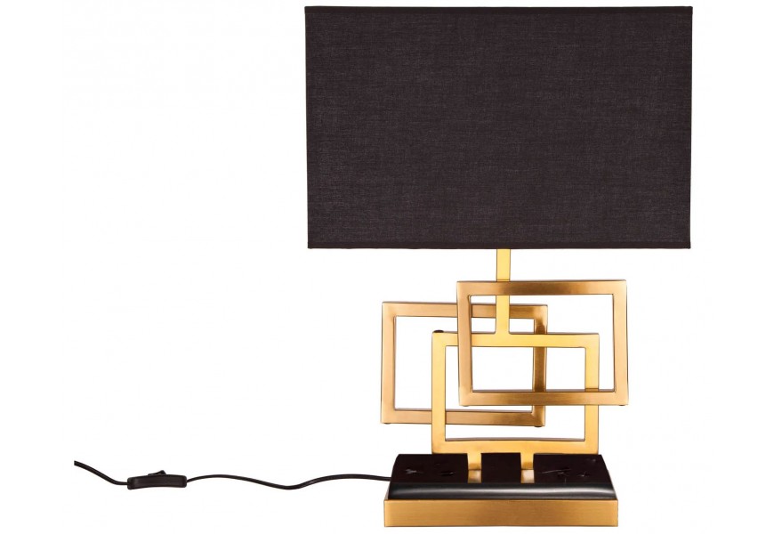 Stolová lampa s čiernym obdĺžnikovým textilným tienidlom a zlatou kovovou konštrukciou z prepojených geometrických rámov