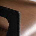 Luxusné moderné kreslo Arthen s čiernou drevenou konštrukciou a hnedým koženým čalúnením s geometrickými opierkami 70 cm