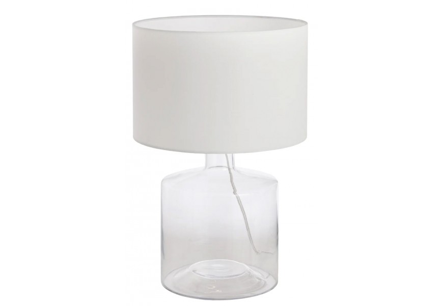 Moderná stolová lampa s bielym valcovým textilným tienidlom a priehľadným skleneným podstavcom v tvare fľaše s viditeľným káblom vo vnútri