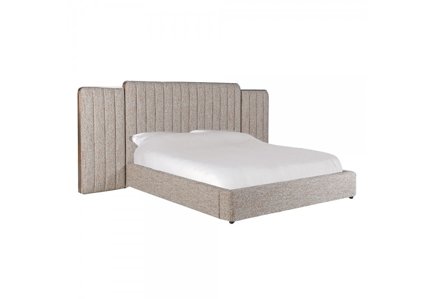 Luxusná glamour buklé manželská posteľ Nubilia so širokým čelom s tromi panelmi s čalúnením v béžovej melírovanej farbe do zaoblenými rohmi a lesklým metalickým detailom v medenej farbe