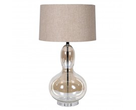 Dizajnová glamour stolná lampa Kayla s nohou z priehľadného skla s hnedým tónovaním so zaoblenou siluetou v tvare hrušky s okrúhlym béžovým ľanovým tienidlom a kovovou konštrukciou v lesklom chrómovom prevedení