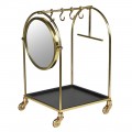 Glamour zaoblený vešiak na kolieskach Arcondo z kovu v zlatej farbe s okrúhlym zrkadlom so štyrmi háčikmi so štvorcovou spodnou policou so štyrmi kolieskami