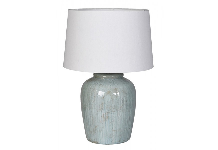 Dizajnová keramická stolná lampa Zippy a nohou v svetlej modrej farbe so zelenou patinou a lesklou glazúrou s bielym valcovitým tienidlom s rozšírenou spodnou časťou