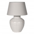 Provensálska keramická biela stolová lampa Corynth s mohutnou okrúhlou podstavou s minimalistickým plastickým zdobením a glazúrou s vysokým leskom s kónickým tienidlom z ľanu