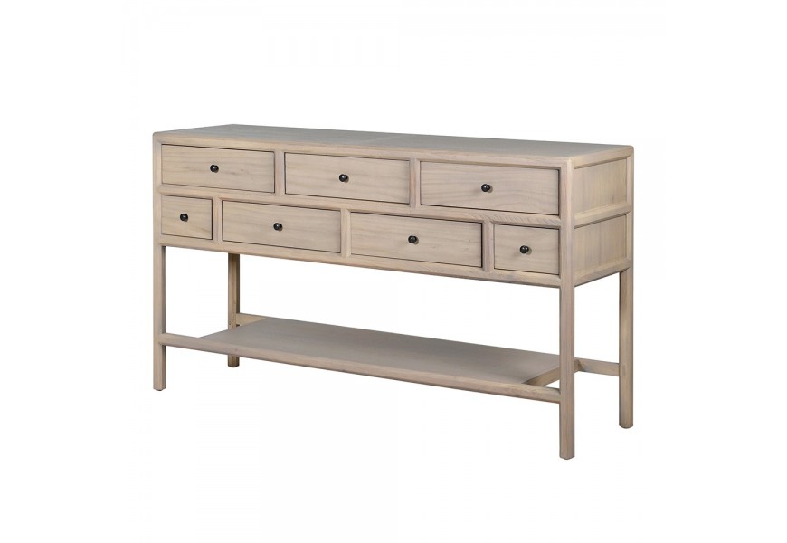 Luxusný moderný masívny obdĺžnikový konzolový stolík Angus so siedmimi zásuvkami s čiernymi okrúhlymi úchytkami v dvoch radoch s dlhými štíhlymi nožičkami a veľkou policou v spodnej časti z masívneho brestového dreva v svetlom hnedom krémovom prevedení