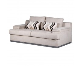 Luxusn&aacute; retro b&eacute;žov&aacute; sedačka Miranda pre dve osoby s plnou podstavou so siv&yacute;m dreven&yacute;m lemom s hranat&yacute;mi bočn&yacute;mi a chrbtov&yacute;mi opierkami a dvomi akcentov&yacute;mi vank&uacute;&scaron;mi s chevronov&yacute;m vzorom s čiernej a zemit&yacute;ch hned&yacute;ch farb&aacute;ch